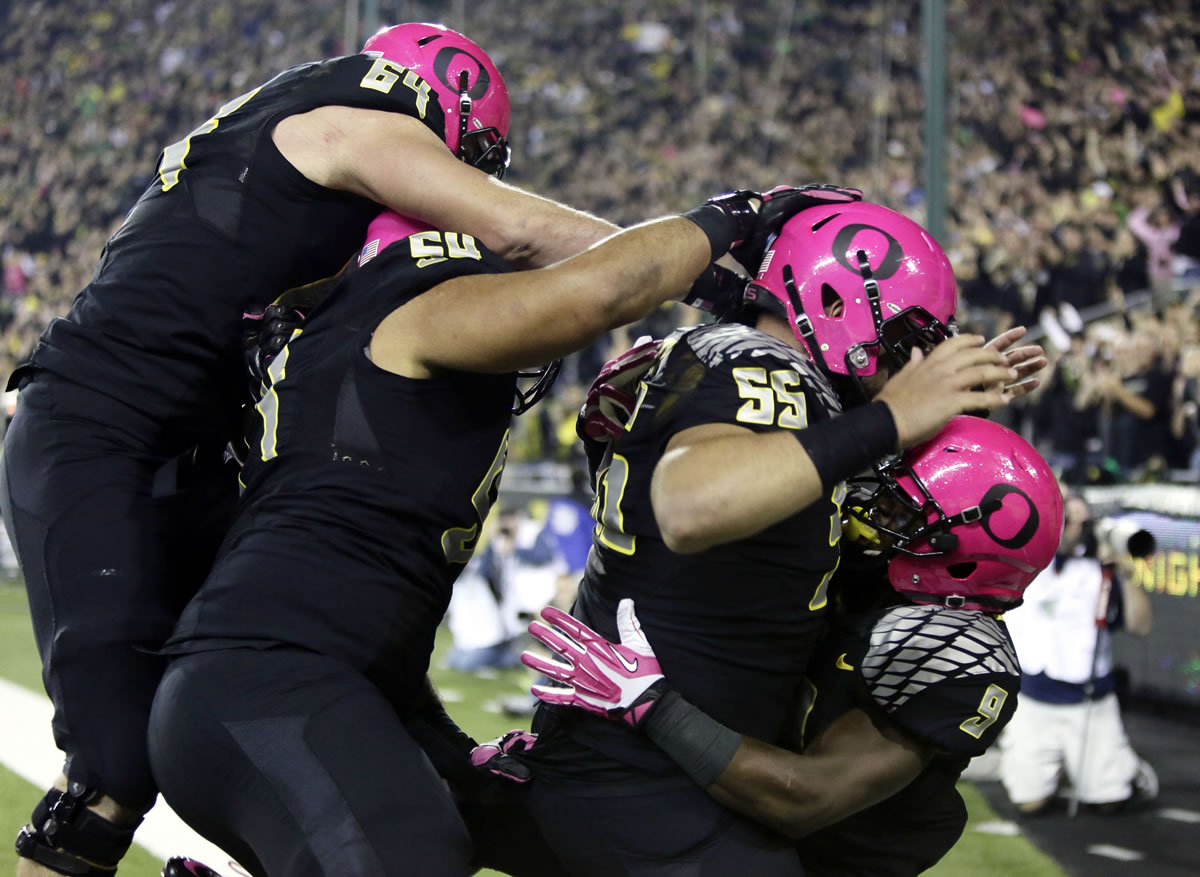 Oregon running back Byron Marshall, right, celebrates his touchdown with teammates, from left, Tyler Johnstone, Hamani Stevens and Hroniss Grasu during the first half of an NCAA college football game against Washington State in Eugene, Ore., Saturday, Oct. 19, 2013.