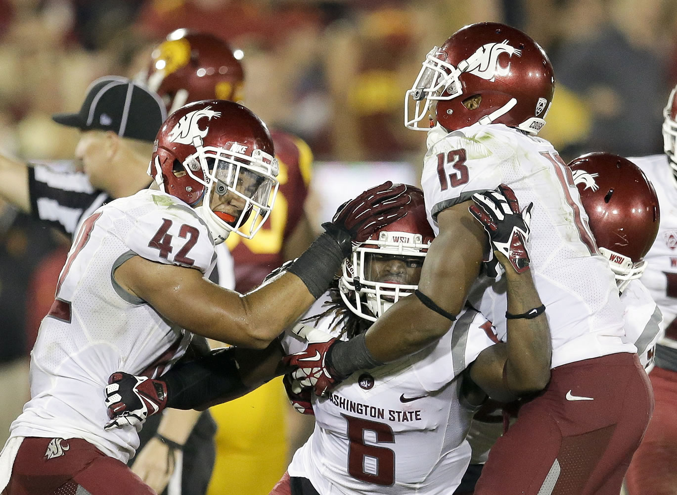 Washington State cornerback Damante Horton, middle, celebrates his interception with teammates Cyrus Coen, left, and Darryl Monroe during the second half of an NCAA college football game against Southern California in Los Angeles, Saturday, Sept. 7, 2013.