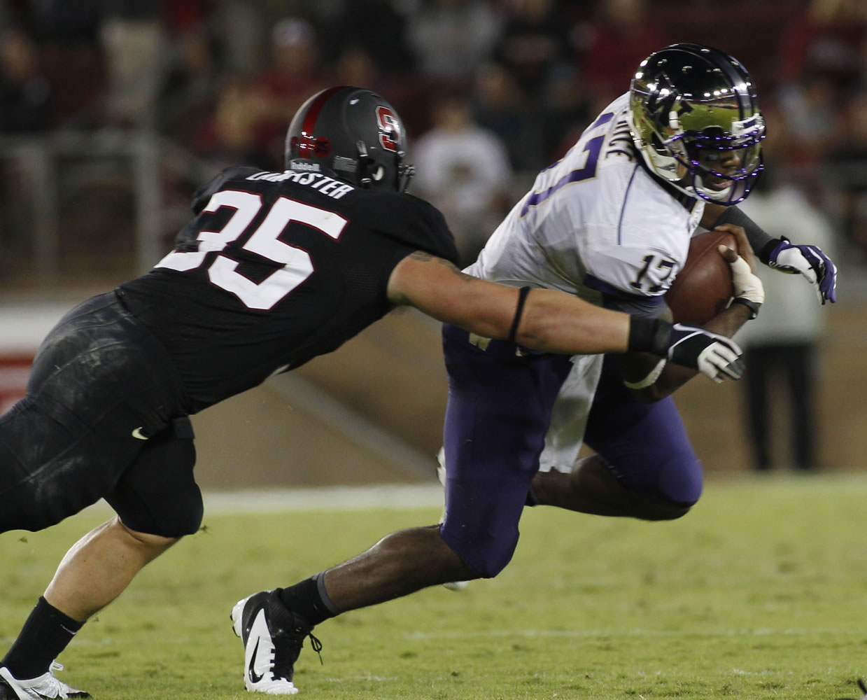 Washington quarterback Keith Price, right, is tackled by  Stanford's Jarek Lancaster during the second half of an NCAA college football game in Stanford, Calif., Saturday, Oct. 5, 2013.