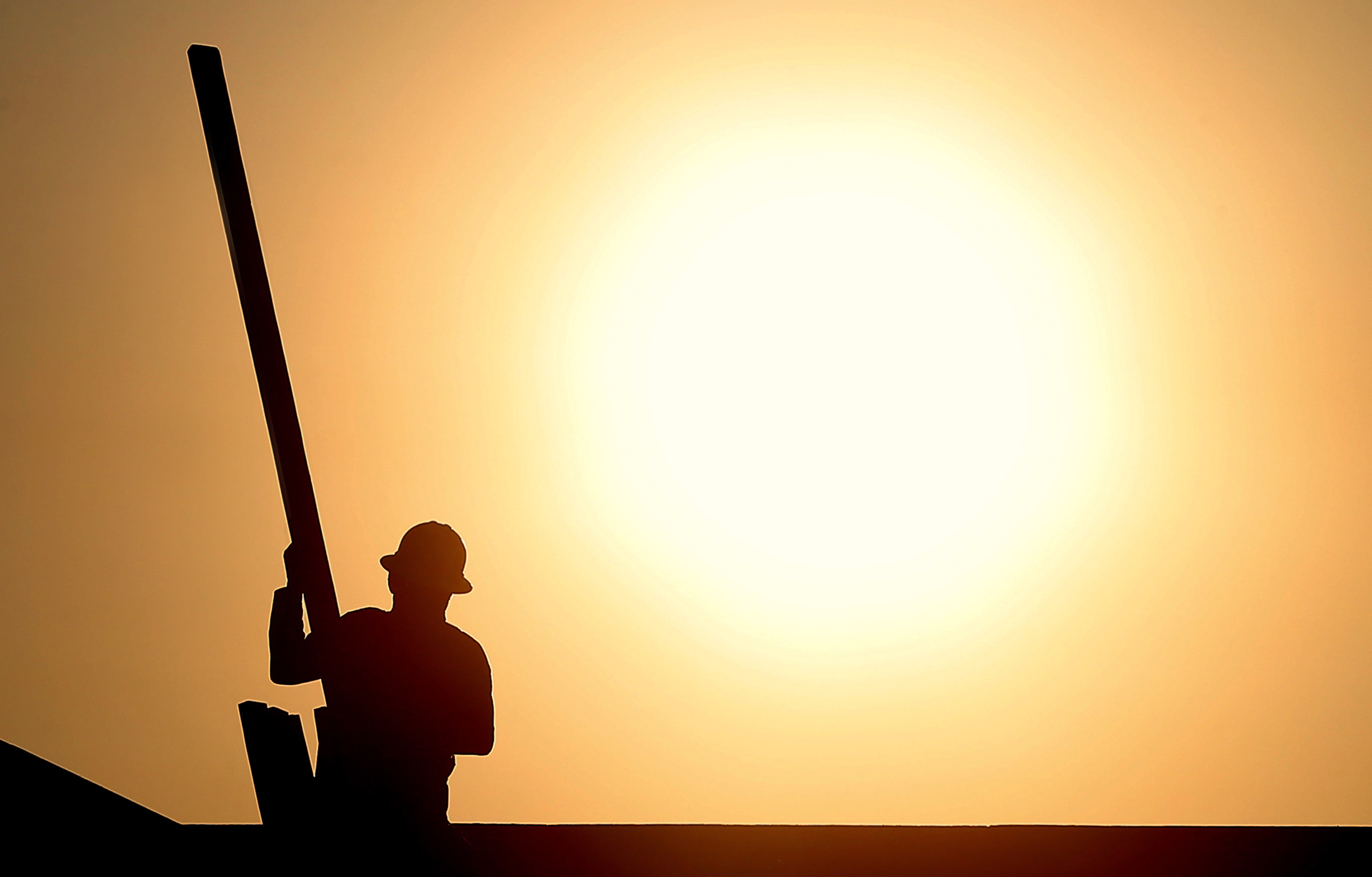 A construction worker is shown atop a roof at sunrise to beat daytime high temperatures, Thursday in Queen Creek, Ariz. Excessive heat warnings will continue for much of the Desert Southwest as building high pressure triggers major warming in eastern California, Nevada, and Arizona.