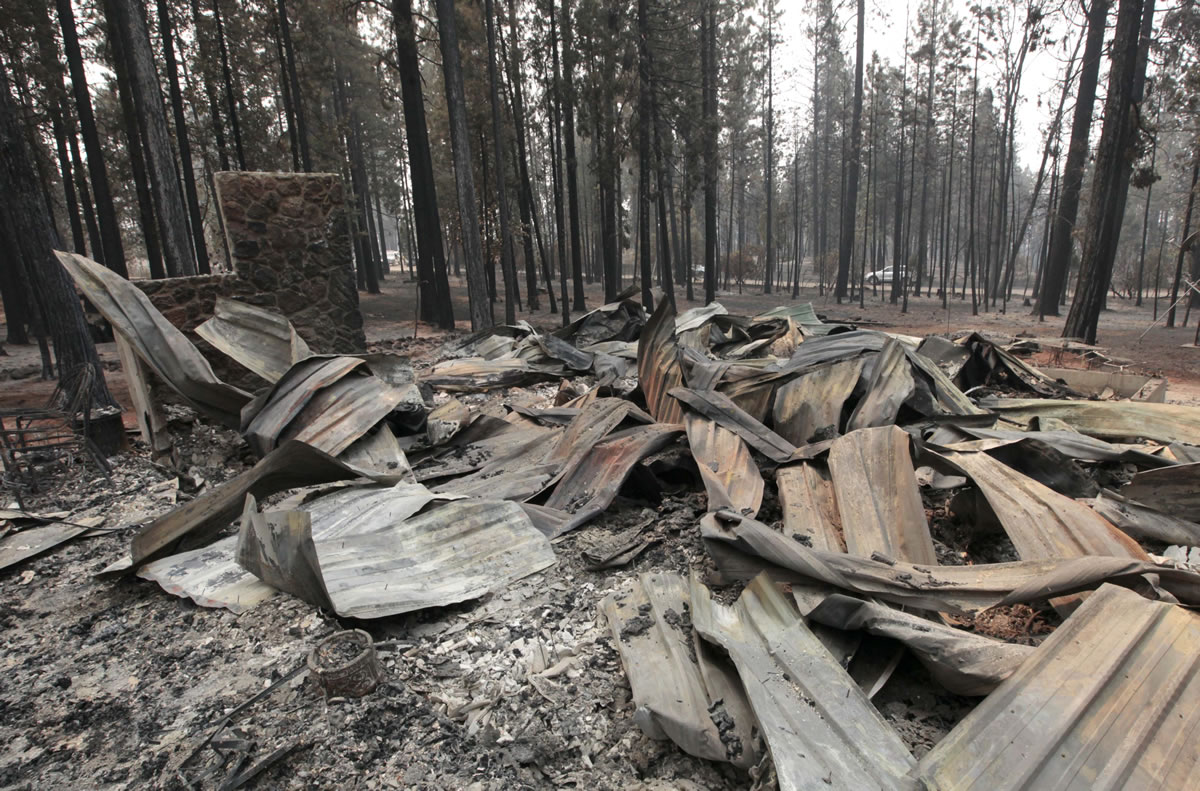 A house near Manton, Calif., is little more than a fireplace and warped pieces of metal roofing Monday after the Ponderosa fire went through. More than 1,400 firefighters are battling the fire that has destroyed seven homes and burned 23 square miles since it started Saturday.