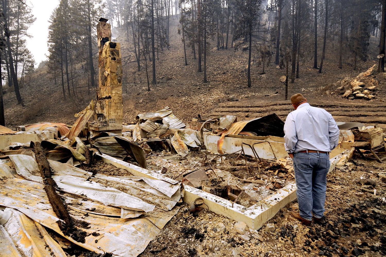 U.S. Sen. Jon Tester, D-Mont., looks at the remains of a Lolo Creek home that was destroyed by the West Fork II fire when it swept down the Lolo Creek canyon Wednesday near Lolo, Mont. The fire burned four other homes as well along the U.S.