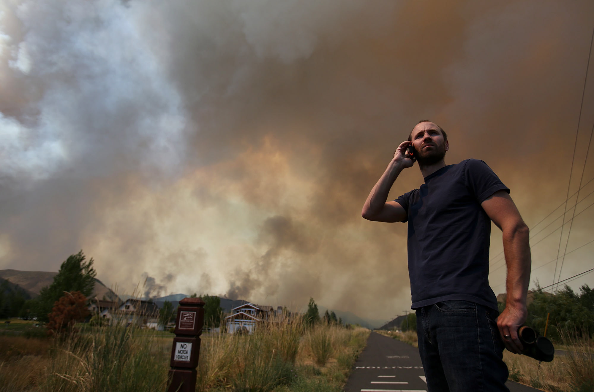 Kevin Bullock, of Bellevue, Idaho, watches smoke from the 64,000 acre Beaver Creek Fire on Friday, Aug., 16, 2013 north of Hailey, Idaho.