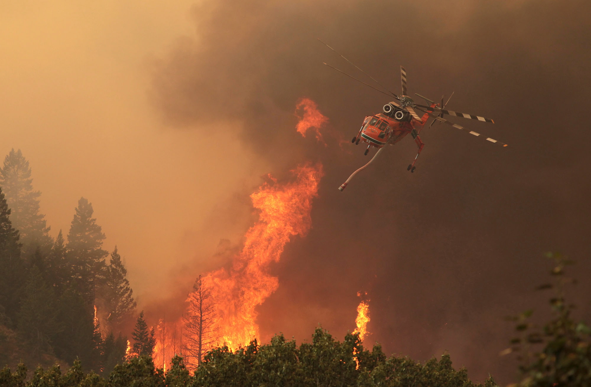 Helicopters battle the 64,000 acre Beaver Creek Fire on Friday, Aug., 16, 2013 north of Hailey, Idaho.