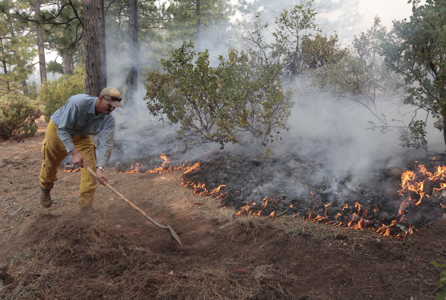 Greg McCarty builds a fire line as flames from the Ponderosa Fire approach the home of a family friend, near Paynes Creek, Calif., on Wednesday.