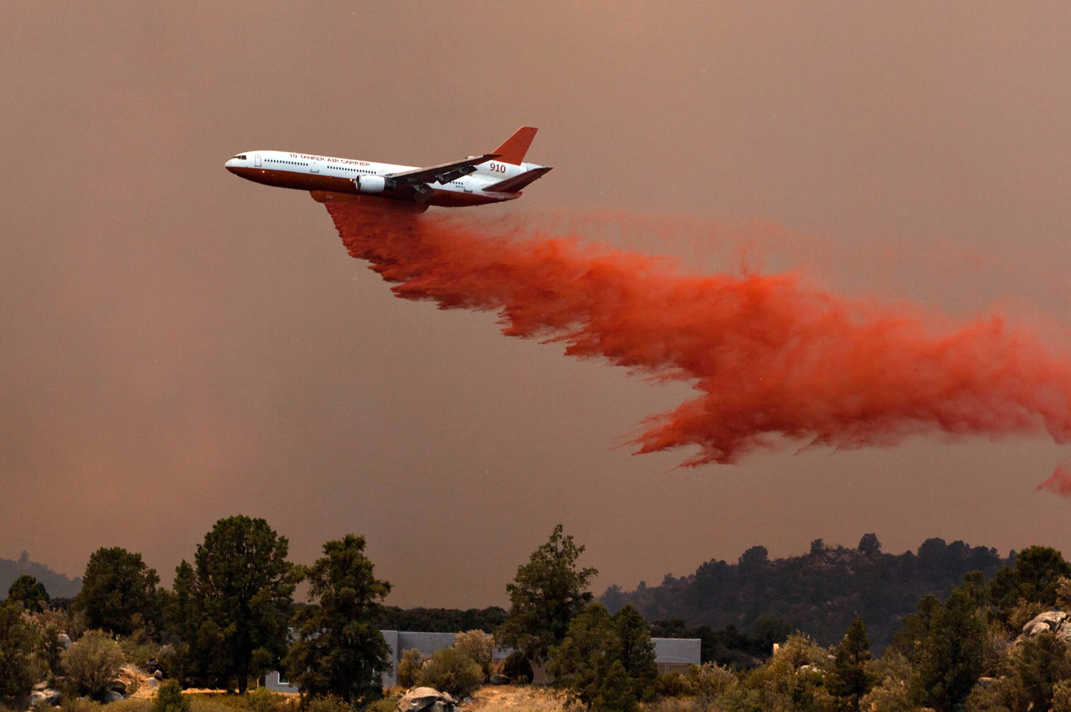 Tanker 910 makes a retardant drop on the Yarnell Hill fire to help protect the Double Bar A Ranch near Peeples Valley, Ariz., Sunday. The fire started Friday and picked up momentum as the area experienced high temperatures, low humidity and wind.
