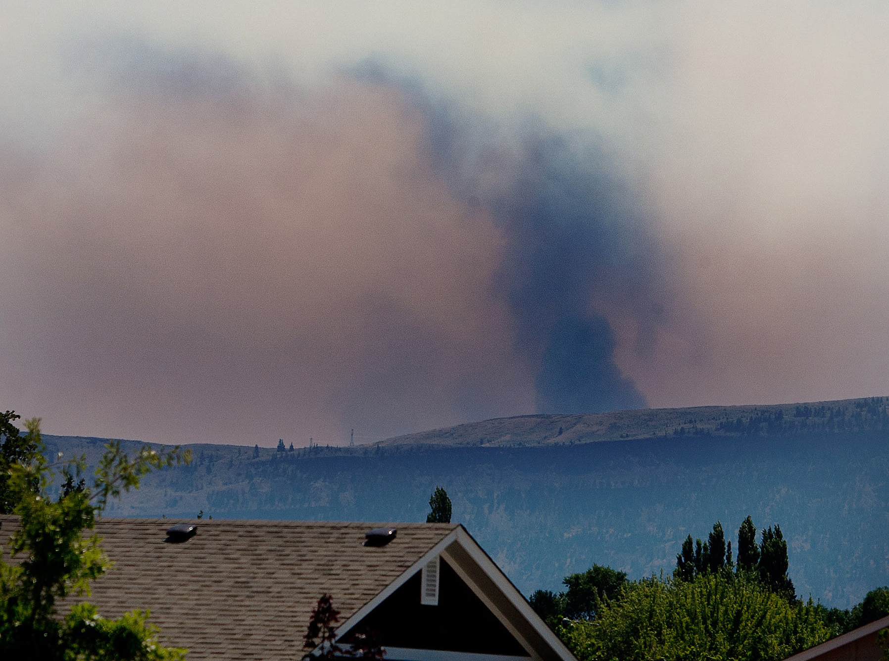 A column of smoke and steam is seen building over the Colockum fire Sunday afternoon from East Wenatchee.