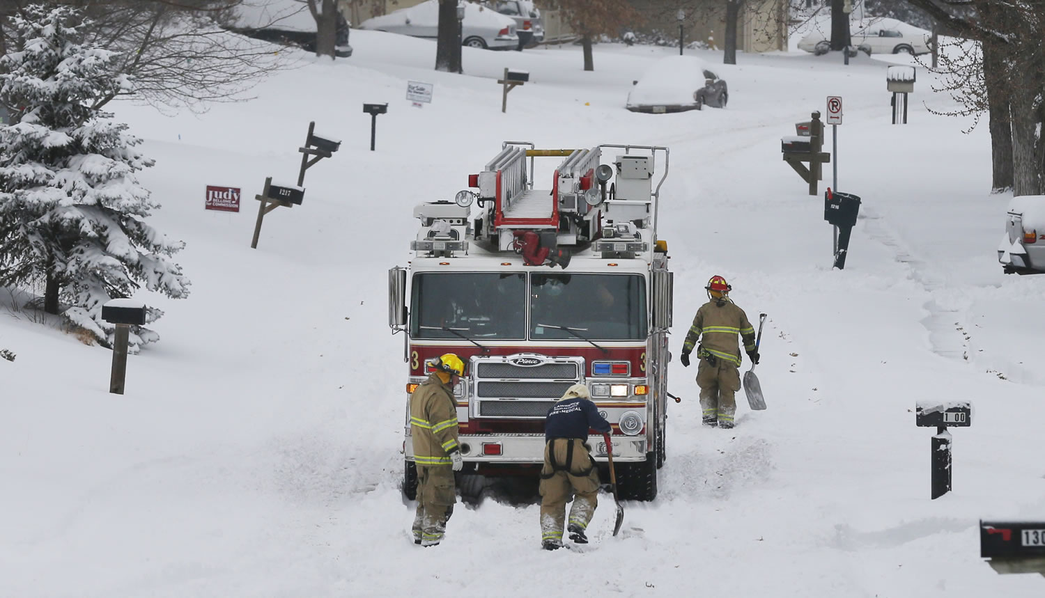Lawrence firefighters shovel as they back out of a snow -overed neighborhood in Lawrence, Kan. on Thursday.