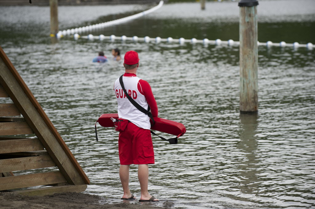 A lifeguard keeps watch over Klineline Pond at Salmon Creek Regional Park on Wednesday. Klineline Pond was closed indefinitely Thursday after routine testing showed elevated levels of E. coli bacteria.