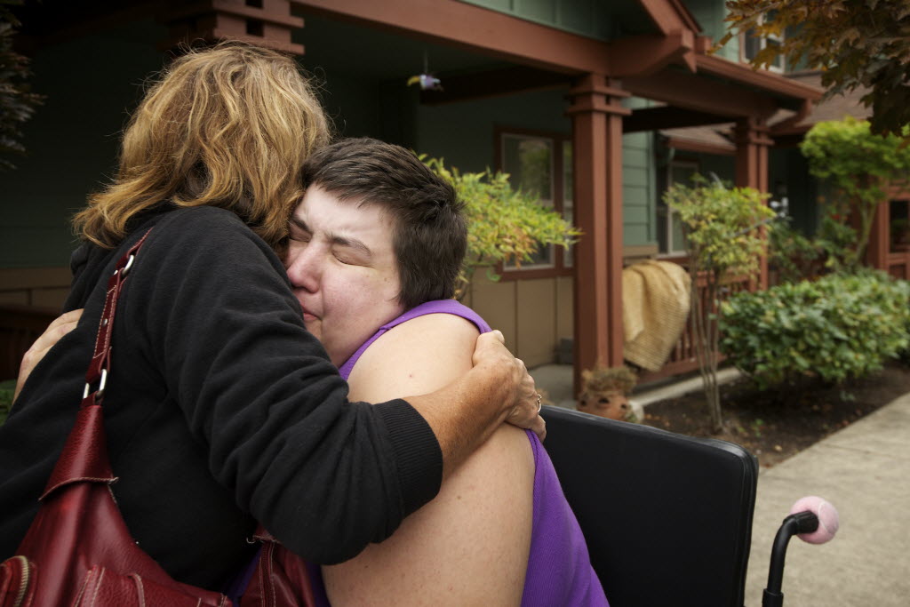 Dustina Haase-Lanier is comforted by family friend Julie Wimber, left, after her apartment caught fire at the Cascadia Village apartment complex this morning.