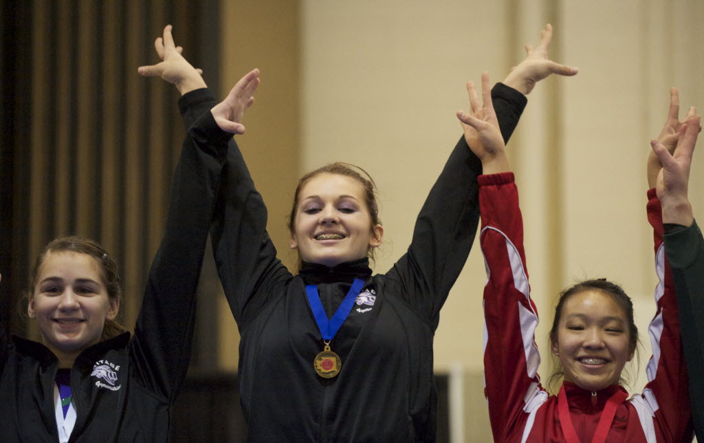 Heritage gymnast Britni Atwell celebrates after receiving the gold medal in the 4A Individual All Around state competition in Tacoma today.