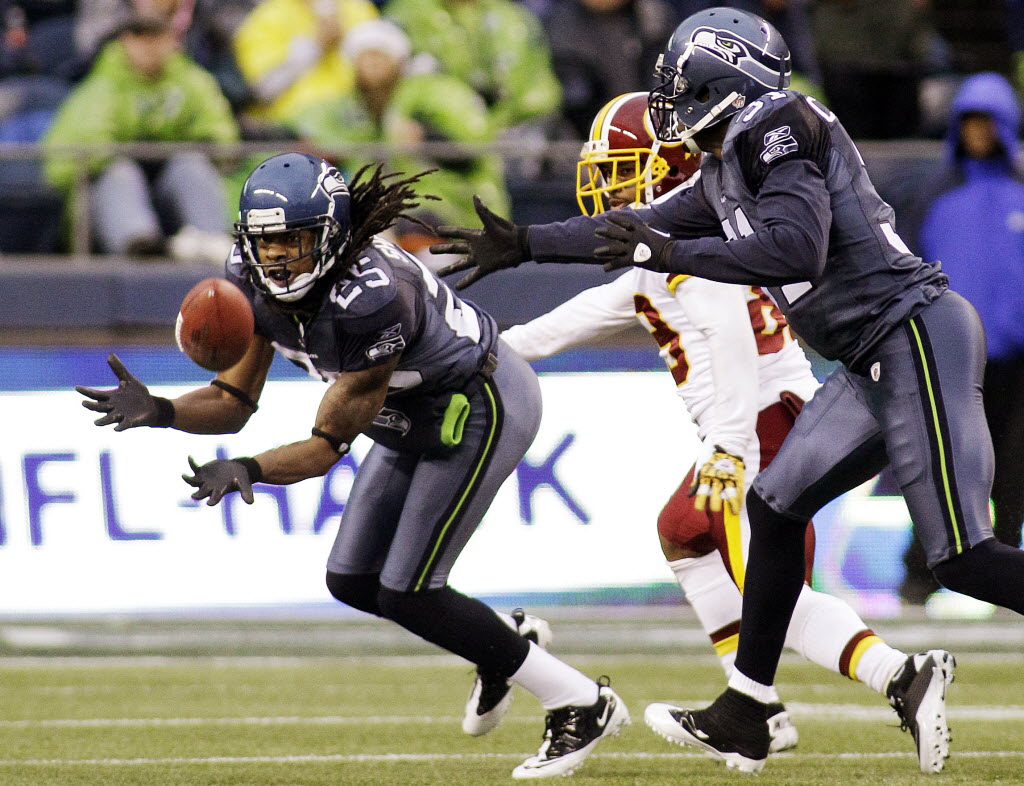 Seattle Seahawks' Richard Sherman, left, intercepting a pass intended for Washington Redskins' Santana Moss, is scheduled to appear in Vancouver in July as part of the &quot;12 Tour&quot; stops throughout the Pacific Northwest.