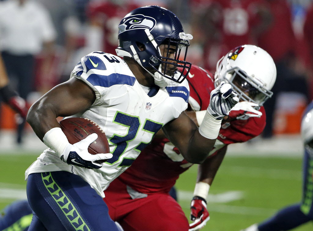 Seattle Seahawks running back Christine Michael (33) runs as Arizona Cardinals outside linebacker Alex Okafor (57) pursues during the first half of an NFL football game, Sunday, Dec. 21, 2014, in Glendale, Ariz. (AP Photo/Ross D.