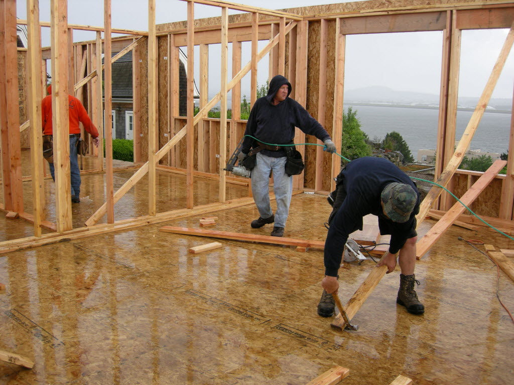 Construction crews work to frame a Colonial-style home under construction in June.