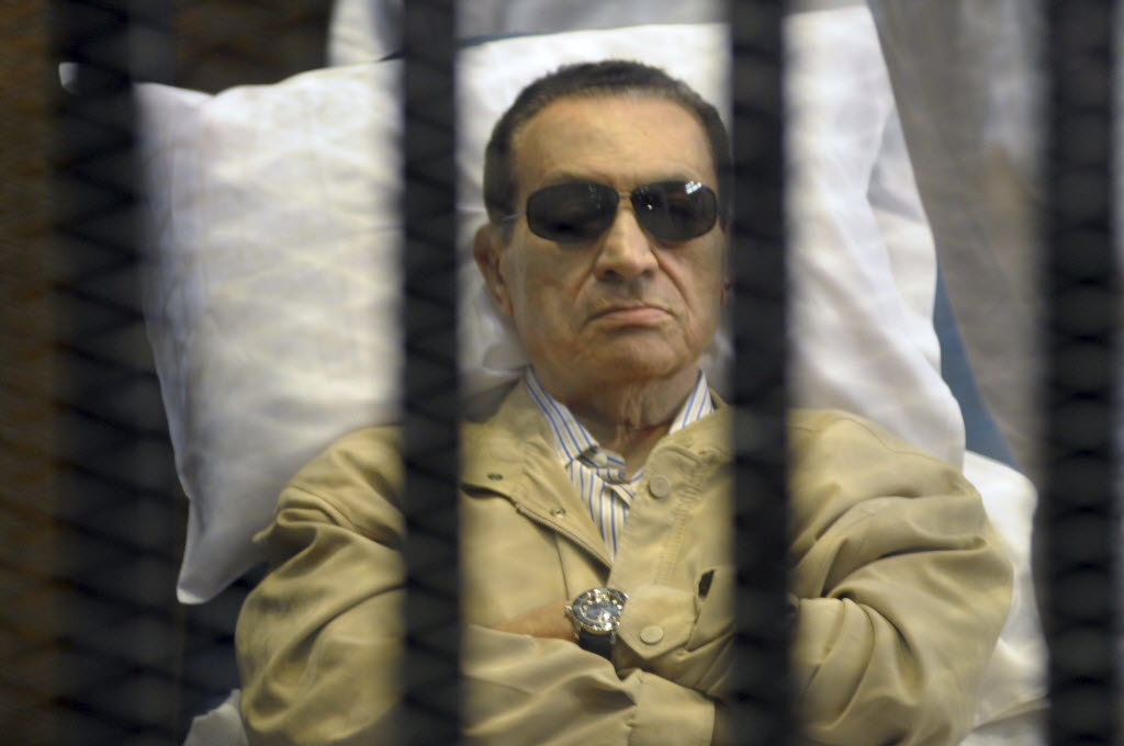 In this June 2 photo, Egypt's ex-President Hosni Mubarak lays on a gurney inside a barred cage in the police academy courthouse in Cairo, Egypt. An Egyptian prison official said Tuesday doctors reported that the 84-year old former president has fallen unconscious.
