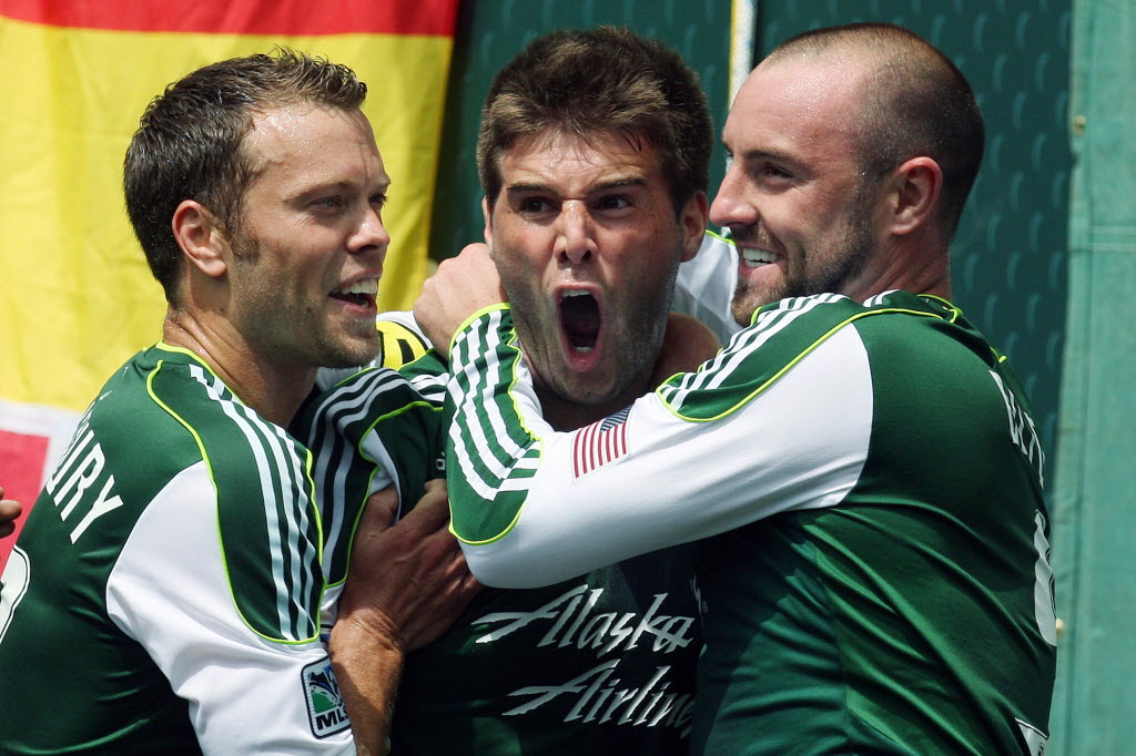 Portland Timbers' David Horst, center, is hugged by Jack Jewsbury, left, and Kris Boyd, right, after scoring in the first half Sunday against the Seattle Sounders.