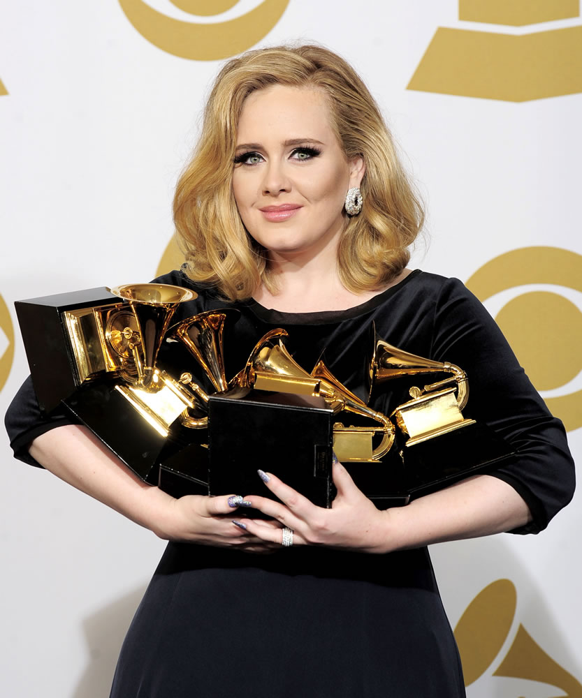 FILE - In this Feb. 12, 2012 file photo, Adele poses backstage with her six awards at the 54th annual Grammy Awards in Los Angeles. Adele won awards for best pop solo performance for &quot;Someone Like You,&quot; song of the year, record of the year, and best short form music video for &quot;Rolling in the Deep,&quot; and album of the year and best pop vocal album for &quot;21.&quot; After a year of Grammy glory and James Bond soundtracking, Adele has been voted The Associated Press Entertainer of the Year. (AP Photo/Mark J.
