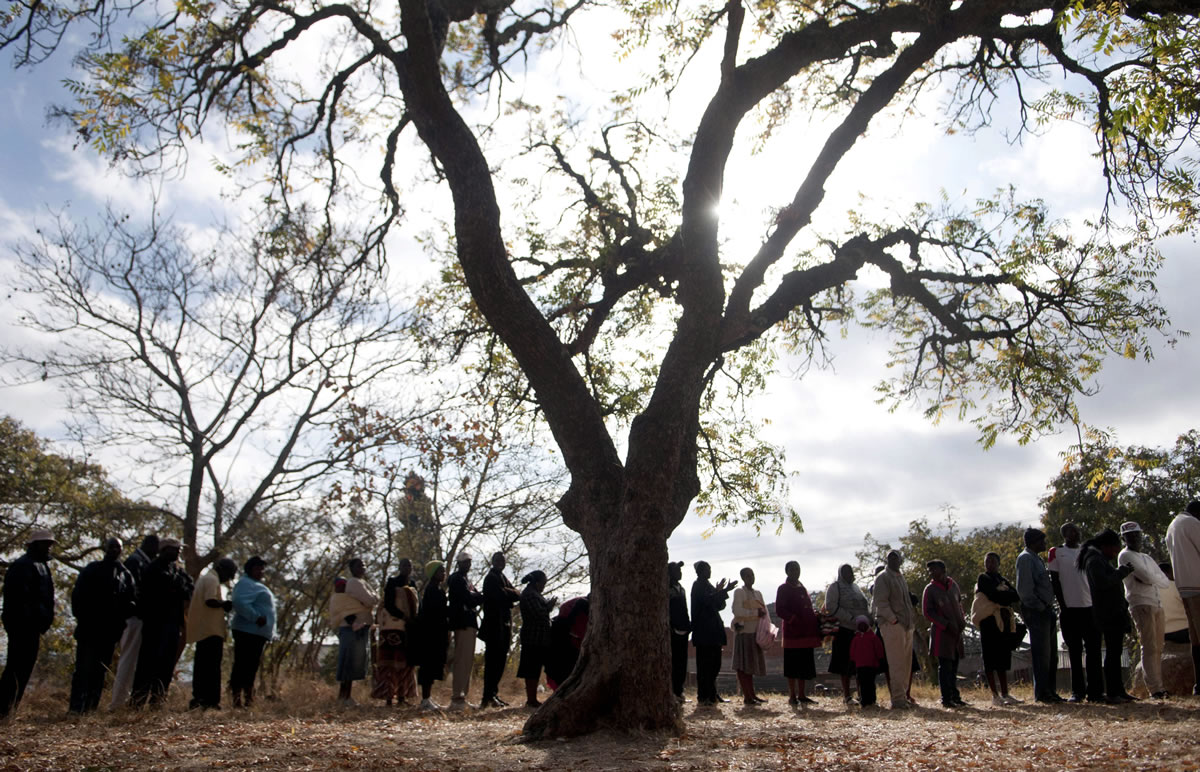 Zimbabweans queue to cast their votes in the country's general elections in Goromonzi, rural Zimbabwe, on Wednesday.