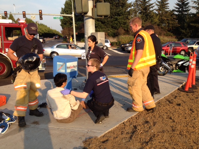 Rescuers tend to a man injured Wednesday in a motorcycle crash at the intersection of Southeast 164th Avenue and 34th Street in Vancouver.