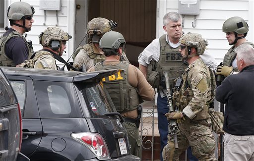 Heavily armed FBI agents gather next door to 410 Norfolk Street in Cambridge, Mass., Friday, April 19, 2013.