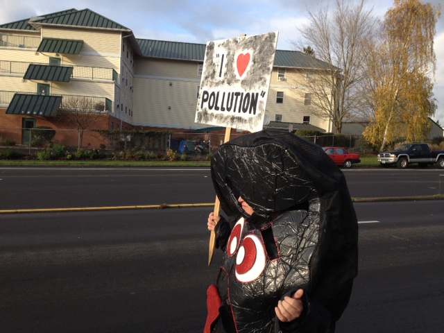 Anti-coal activist Rick Schmitt, 51, of Vancouver protests Wednesday afternoon in advance of a public hearing at Clark College on a proposed coal export facility near Bellingham.