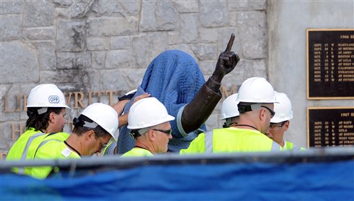 Penn State Office of Physical Plant workers cover the statue of former football coach Joe Paterno near Beaver Stadium on Penn State's campus in State College, Pa., on Sunday.