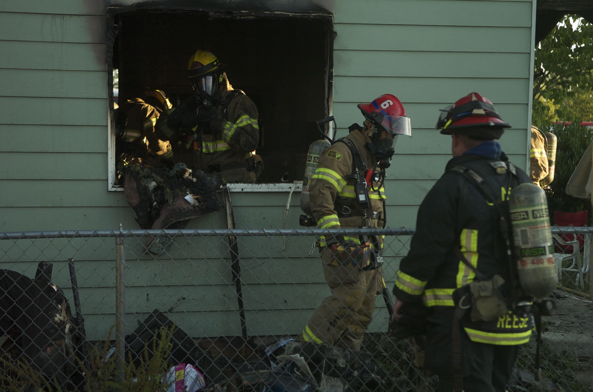 Firefighters on Tuesday morning work to clean up a Salmon Creek house after an early morning fire caused significant damage.