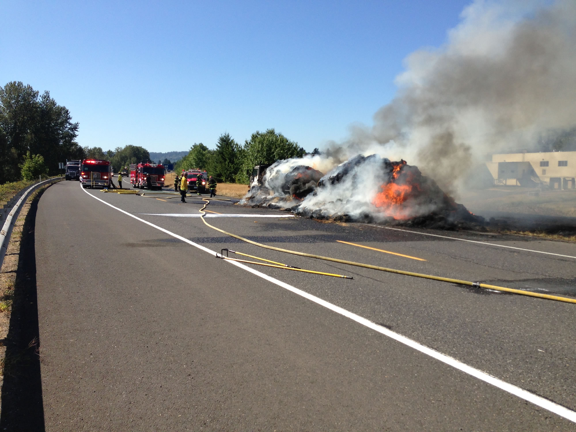 Fire personnel are working to contain a grass fire that appears to have started from a hay truck that caught fire along state Highway 14 in Washougal.
