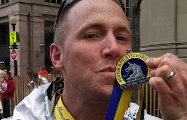 Vancouver resident Micah Rice, The Columbian's news editor, kisses his medal after completing the Boston Marathon on Monday. Rice is among nearly 30 runners from Clark County who participated in the race.