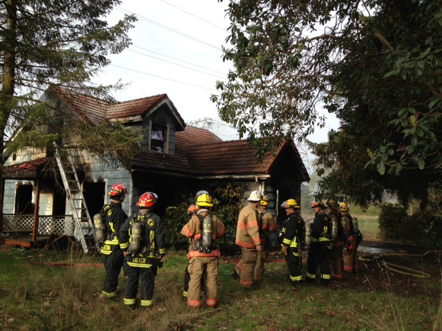 Vancouver firefighters examine the damage to an abandoned east Vancouver home that burned Wednesday afternoon.
