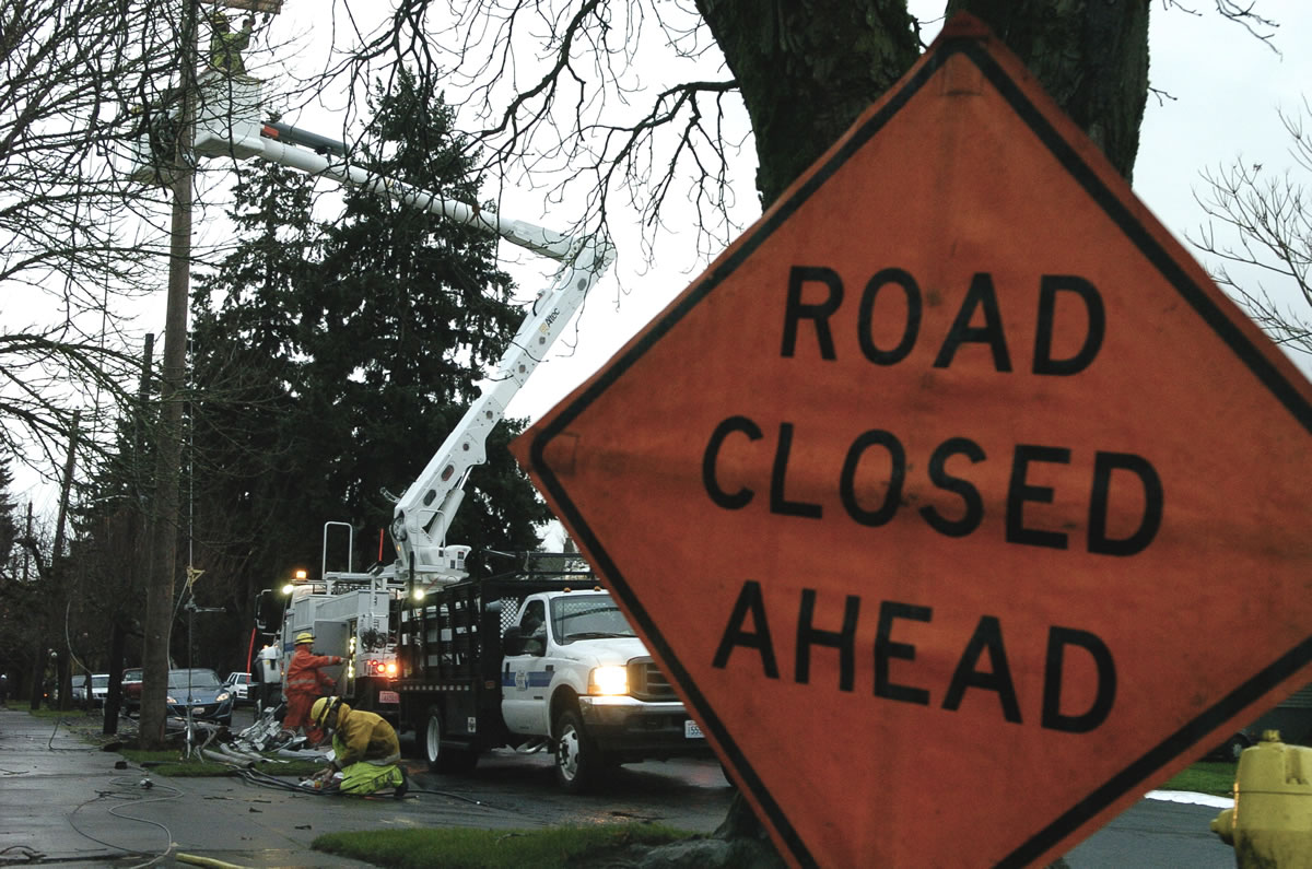 Clark Public Utilities crews work to repair a power line damaged by a tree near 28th and Main streets in west Vancouver early Monday.