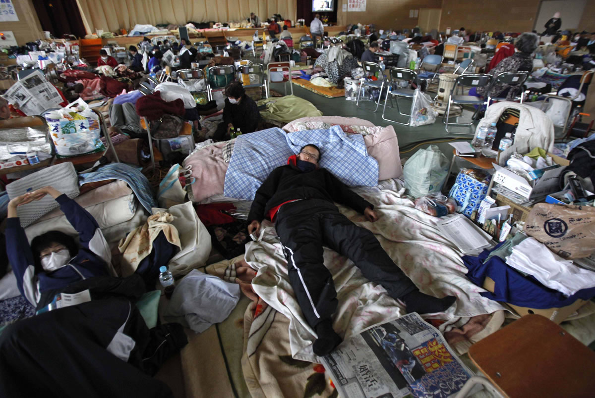 FILES/Associated Press
An evacuee sleeps on a blanket at a shelter in Rikuzentakata, Iwate Prefecture, after the 2011 magnitude 9.0 earthquake and tsunami in Japan. A similar earthquake in the Pacific Northwest caused by the Cascadia fault could pack shelters for months and destroy the regional economy.
