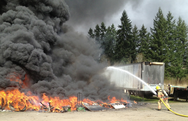 Firefighters battle a large tire fire in Ridgefield, estimated to be 50-feet by 50-feet.