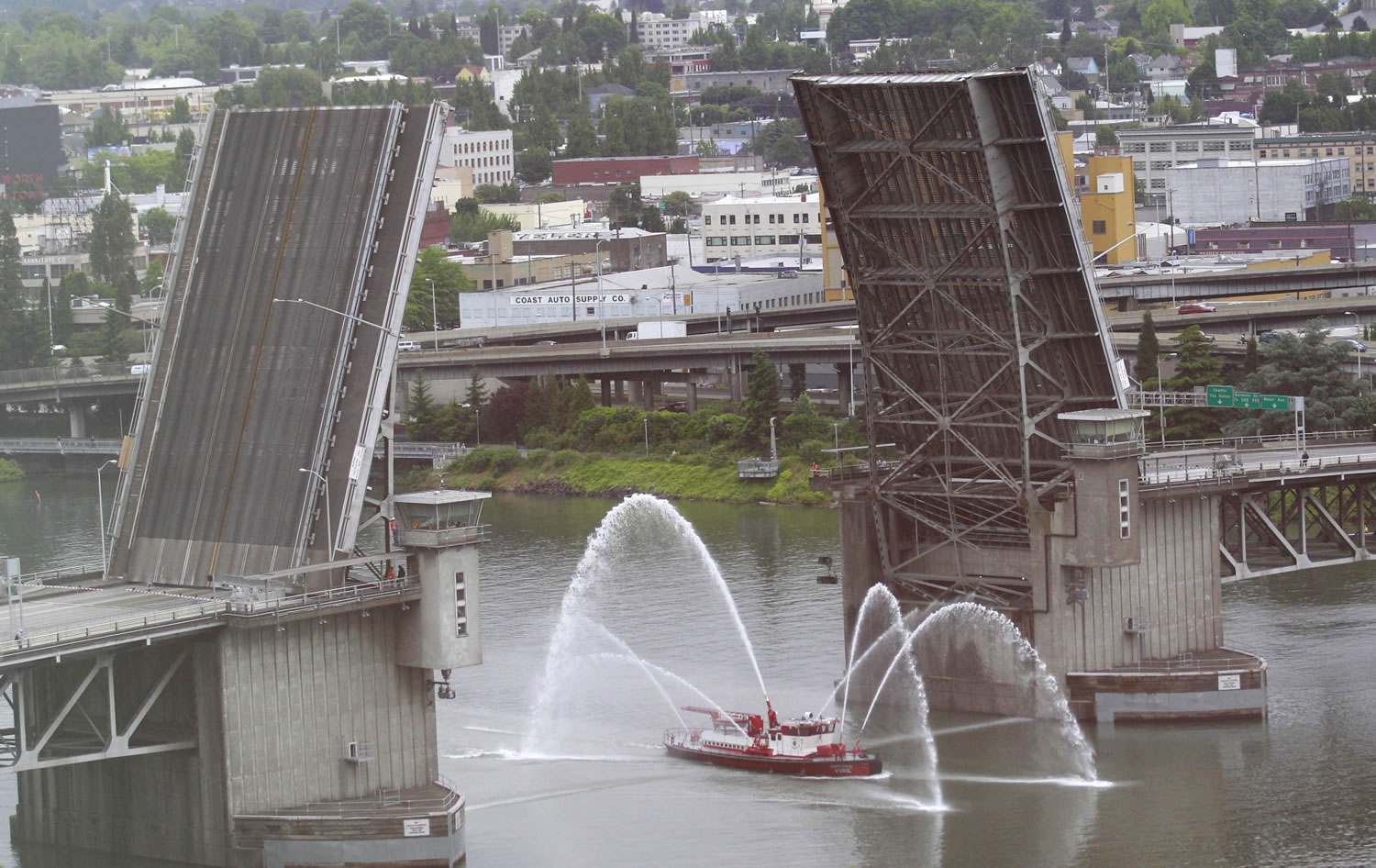 A Portland Fire Department fire boat shoots water into the air as it passes under the Morrison Bridge to celebrate the start of the Rose Festival fleet week Wednesday, June 8, 2011.