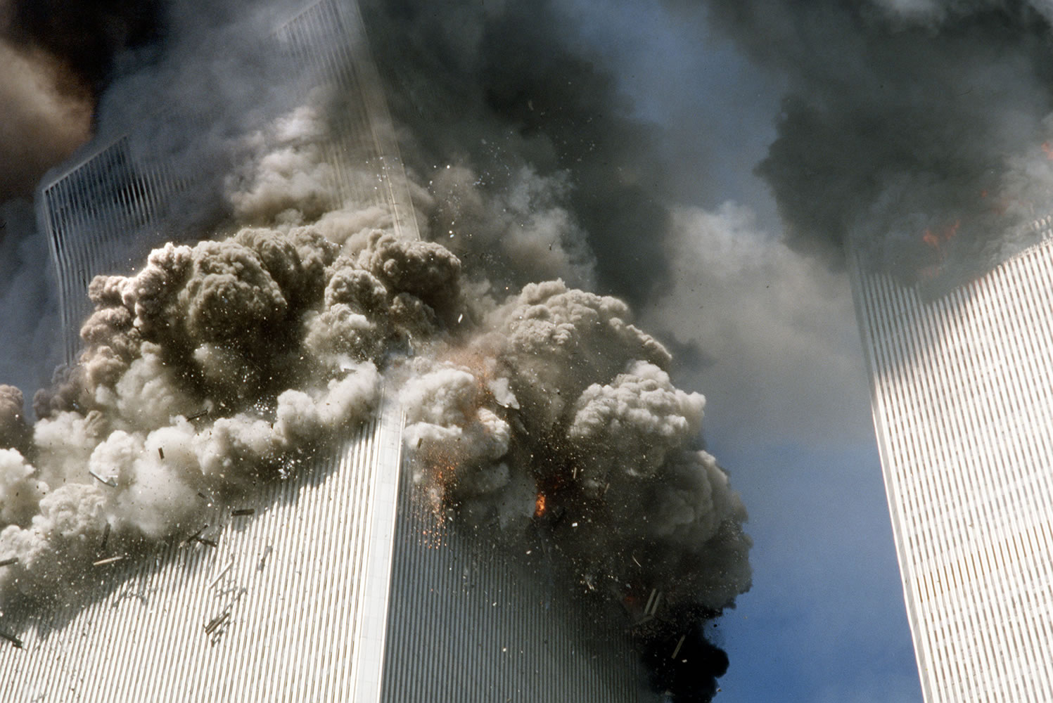 The south tower of the World Trade Center, left, begins to collapse after a terrorist attack on the landmark buildings in New York, Tuesday, Sept.