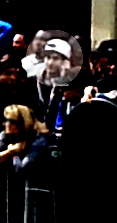 An image from video of the person that the FBI is calling suspect number 2 with a white hat, highlighted, walking in Boston on Monday before the explosions at the Boston Marathon.