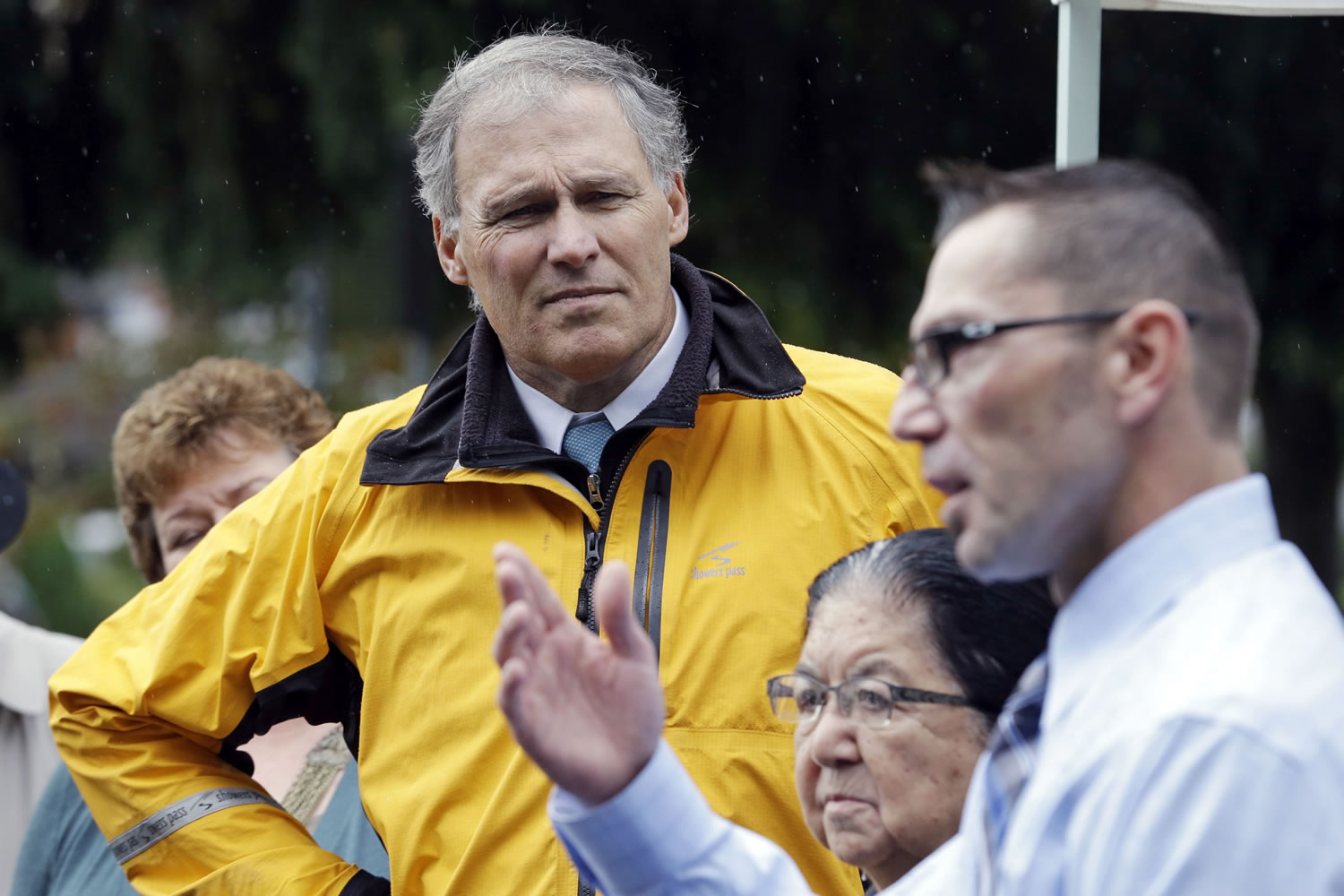 Gov. Jay Inslee, left, and Muckleshoot Chairwoman Virginia Cross look on as Muckleshoot Tribal Council member and Fish Commission Chair Louie Ungaro, right, speaks before a brief tour at the Green River in Auburn in 2014.