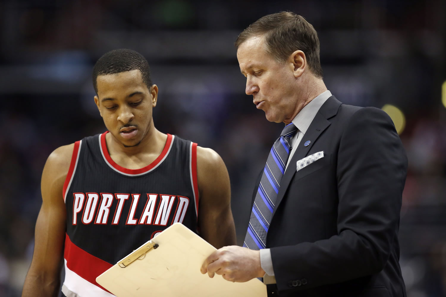 Portland Trail Blazers guard C.J. McCollum (3) watches as head coach Terry Stotts draws a play in the second half of an NBA basketball game against the Washington Wizards, Monday, Jan. 18, 2016, in Washington. The Trail Blazers won 108-98.