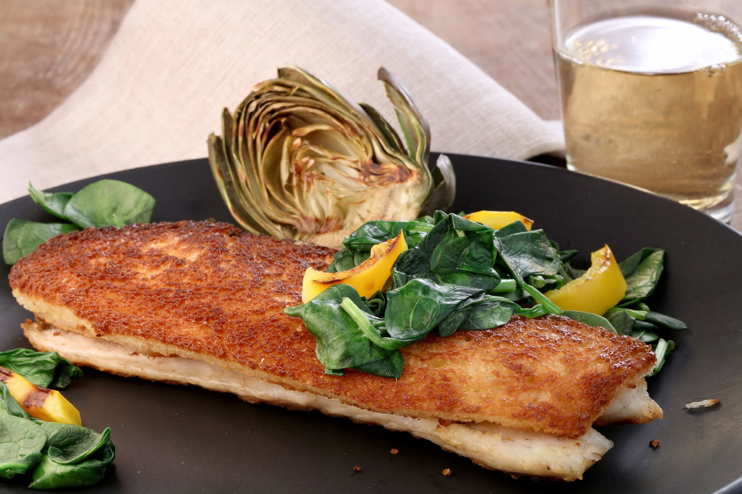 Branzino en croute is created by pan-frying fillets of the fish with planks of bread.