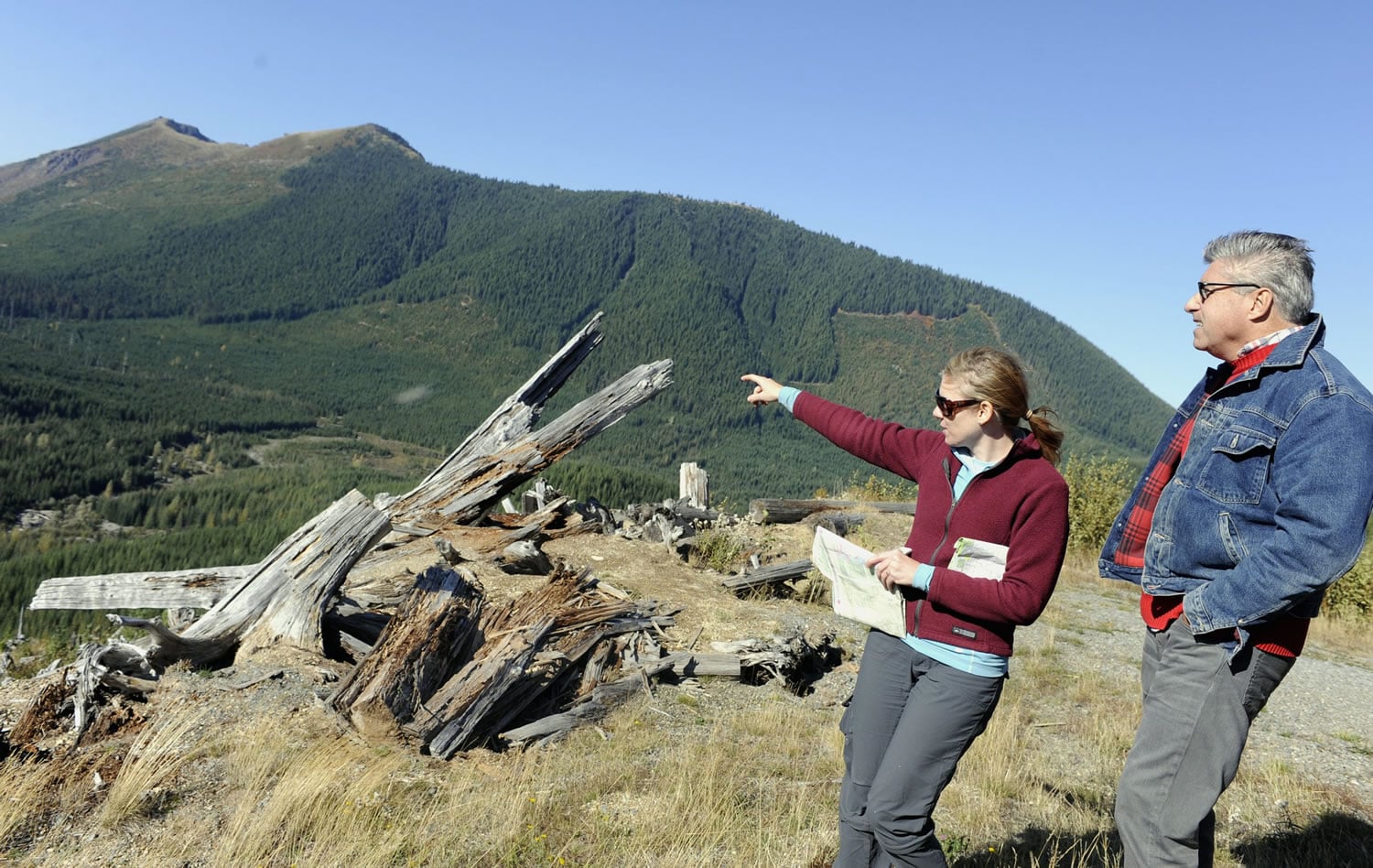 In this 2011 photo, Jessica Walz, with Bob Dingethal, right, both from the Gifford Pinchot Task Force, points to the area where Ascot Resources wants to do exploratory drilling above the Green River and on the border of the Mount St. Helens National Volcanic Monument.