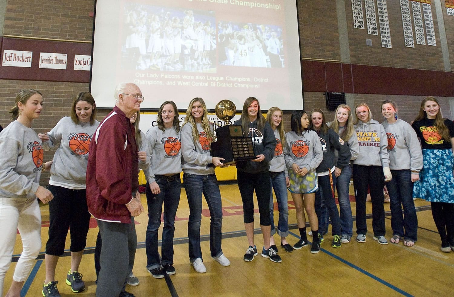 Chuck Thurman stands with the Prairie girls basketball after the Falcons won the 2012 3A state championship.