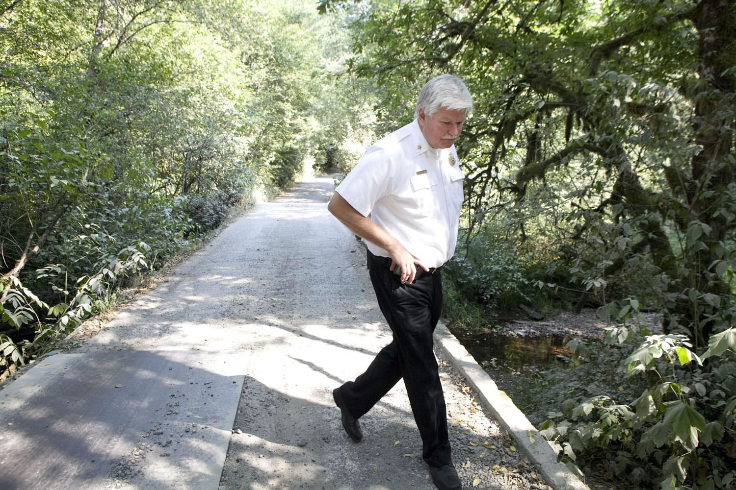 Clark County Fire District 3 Chief Steve Wrightson walks in September on a private bridge in Brush Prairie.