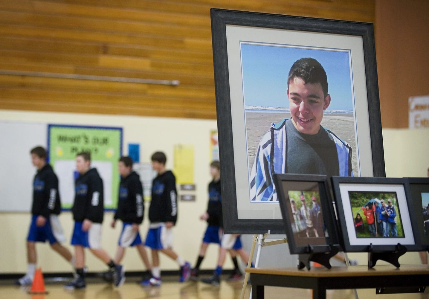 Members of the La Center Middle School's basketball team enter the gymnasium amid photographs of Cody Sherrell during a memorial ceremony at La Center Middle School in January.