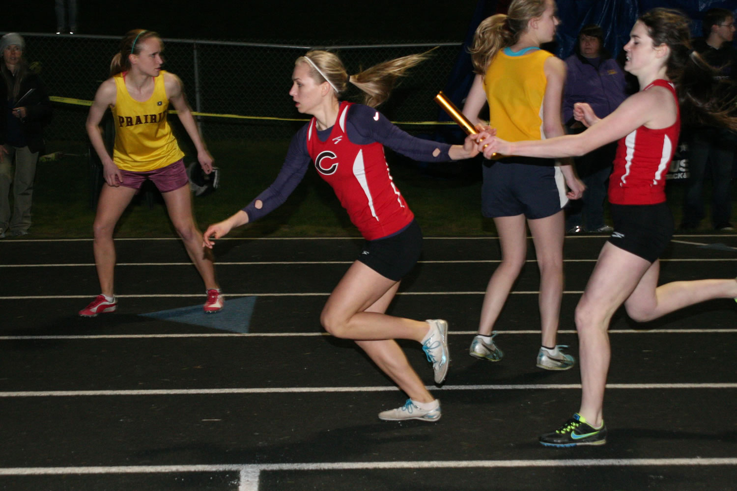 Savanna Joyce hands the baton off to Austen Reiter during the final race of the John Ingram Twilight track and field meet Friday, at Columbia River High School.