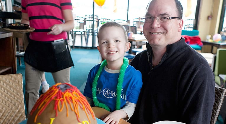 Washougal resident Coleman Merle, 5, sits with his dad, Tim, during a Make-A-Wish Oregon party held at Beaches Restaurant in Vancouver on Friday.