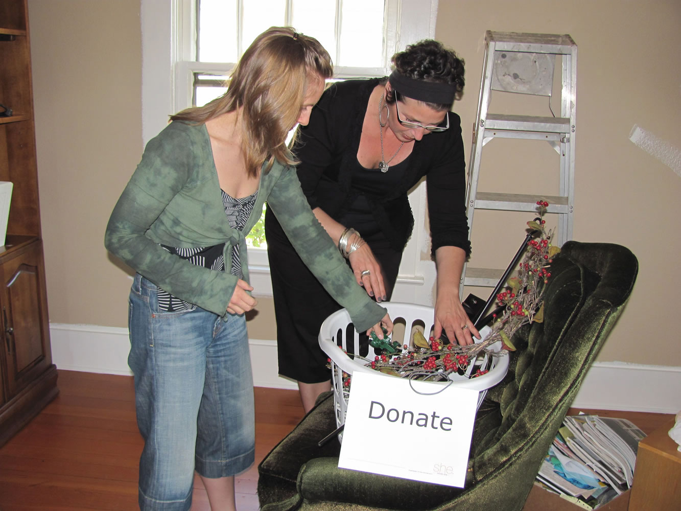Professional organizer Krista Colvin (right) helps Jamie Twyman organize a room so she can offer in-home massage therapy.