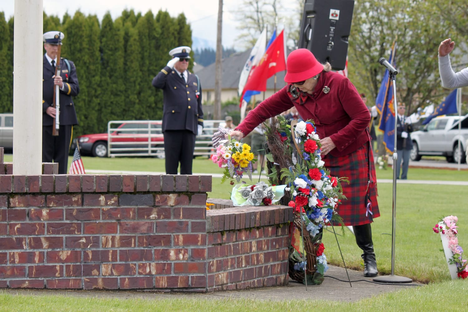 Ninety-four-year-old Lila Trammell, representing the Gold Star Mothers and wearing the Robertson family tartan, places a bouquet of flowers during the Memorial Day ceremony at the Washougal Memorial Cemetery. Trammell's mother, Inez Butler, was a member of the Gold Star Mothers, which is an organization of mothers who have lost a son or daughter serving in the military. Escorting Trammell on Monday were her brother, Harold Robertson, 90, and her son, Lyle Sanders, 73. Sanders said many members of his family have served in the military. &quot;That has been a tradition of our family,&quot; he said.  &quot;It's our country; we defend it.&quot; The event also included speeches by Dave Shoemaker and John Clapp.