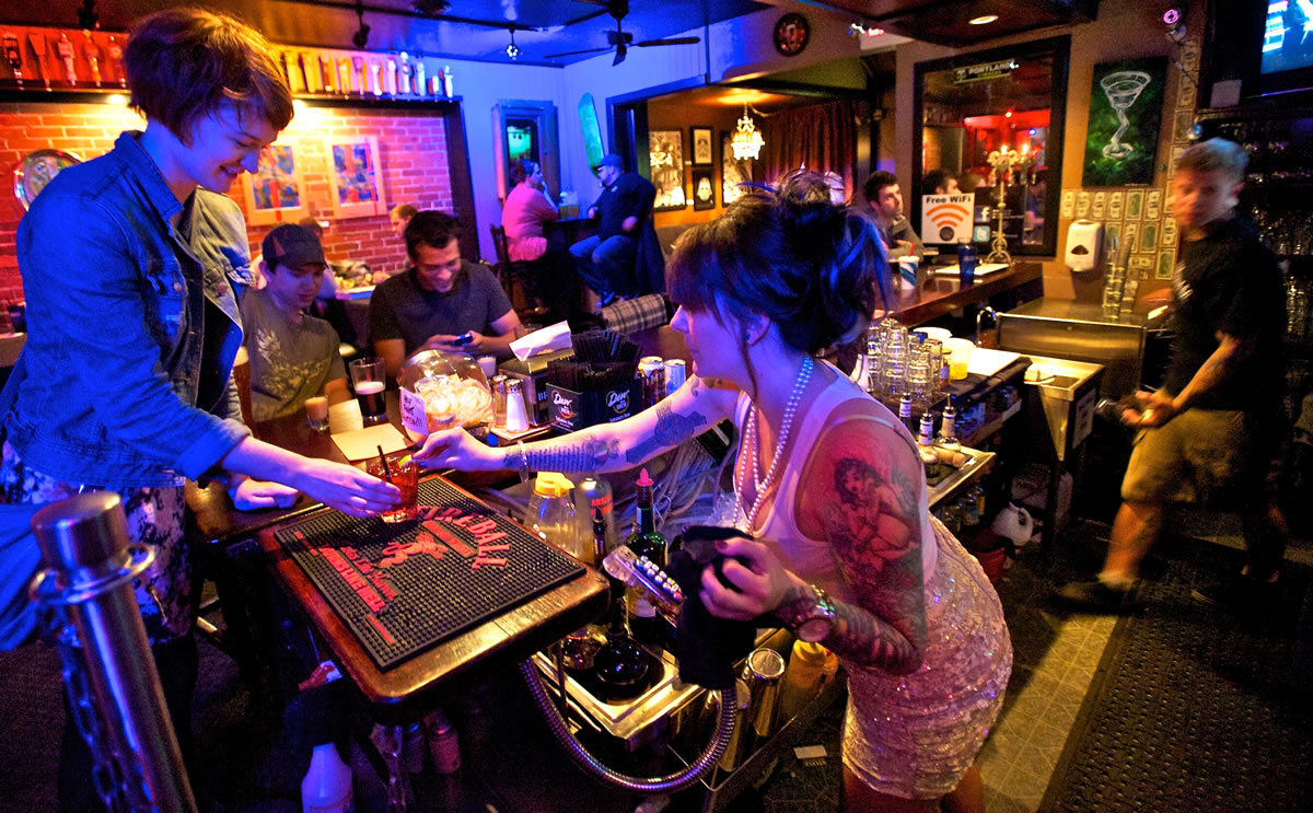 Brickhouse Bar &amp; Grill owner Angela Deans, right, serves Tasha King, 21, of Vancouver a vodka and cranberry juice cocktail.
