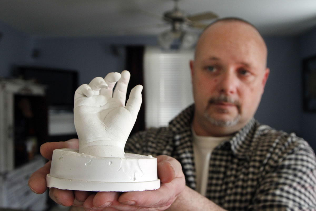 In this January photo, former Clark County Sheriff's Deputy Ed Owens holds a plaster hand casting taken from his son Ryan at the hospital shortly after his 2010 death from an accidental shooting.