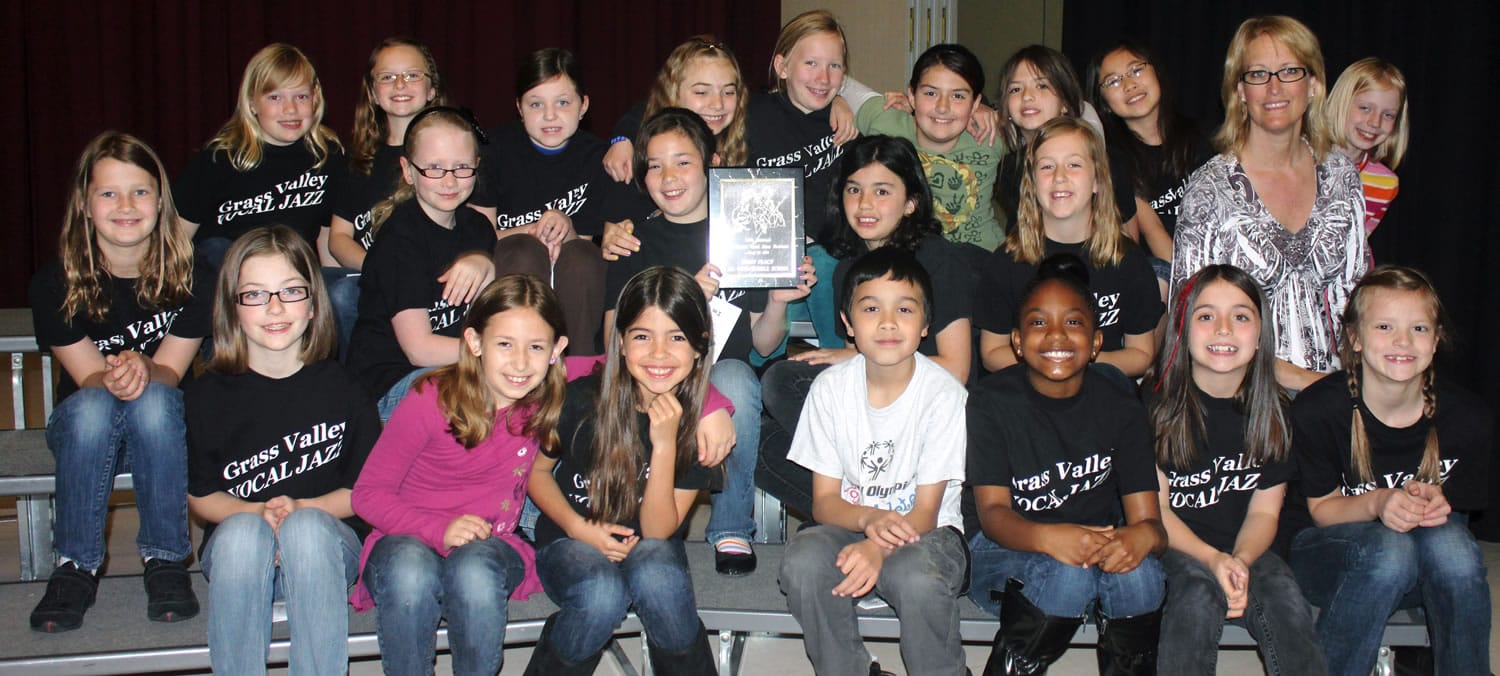 Choir members show off their first-place trophy from a recent festival.